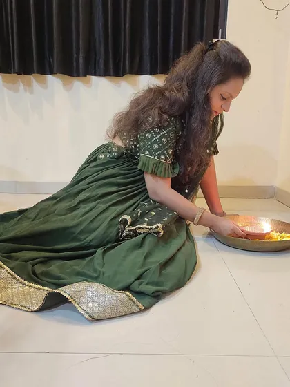A candid moment of my client during Diwali celebrations in her custom green lehenga. The outfit is designed to be comfortable enough for sitting and participating in traditional ceremonies.