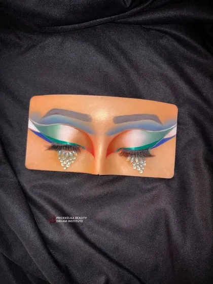 Because your eyes should always tell a story. This dramatic eye makeup on a practice board features bold colors and teardrop rhinestones.