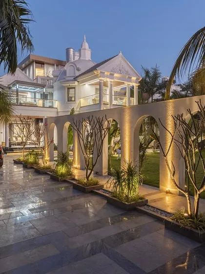 At the "Tropical Manor," nightfall transforms the space. Strategic lighting highlights the dramatic arched wall, turning a simple walkway into a captivating experience. This demonstrates our belief that a well-designed space should be enchanting at any hour.