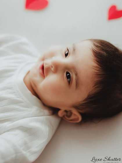 A sweet, angelic face surrounded by little red hearts. A simple and adorable setup for celebrating a milestone like Valentine's Day or just love itself.