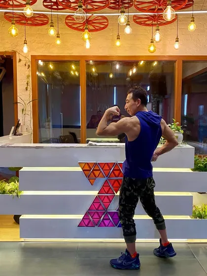Flexing to show impressive bicep and back definition. This is a testament to the power of disciplined strength training over time.