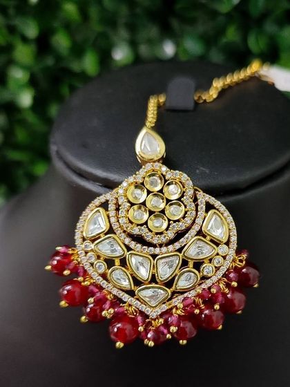 Another variation of the large kundan maang tikka, this one featuring beautiful red beads.