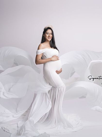 The flowing white fabric creates a sense of movement and grace in this dynamic studio shot.