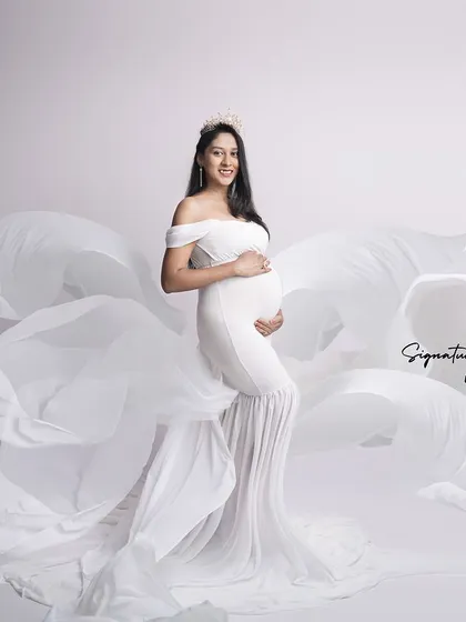 The flowing white fabric creates a sense of movement and grace in this dynamic studio shot.