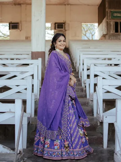 The full look of the client with her purple lehenga and floral half-updo.
