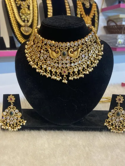 A unique choker with peacock motifs and sparkling white stones, combining traditional design with modern elegance.