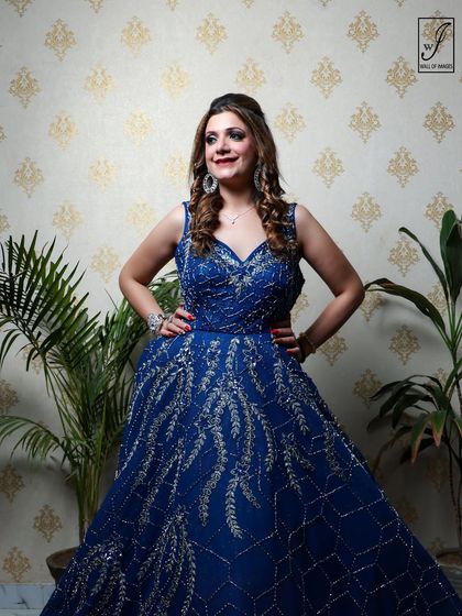 A full-length view of the blue gown, displaying its elegant silhouette and the intricate silver embroidery that catches the light.