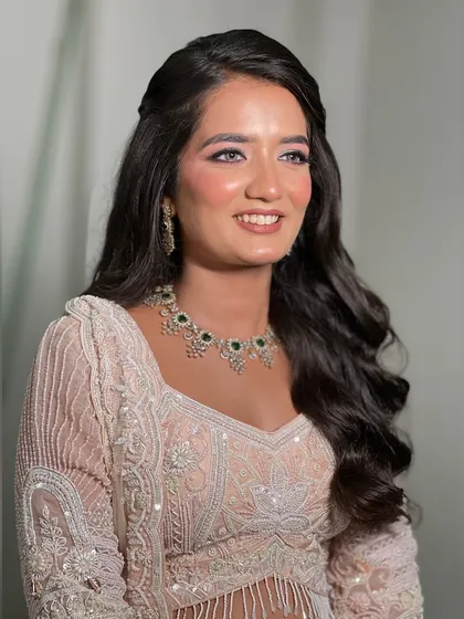 A soft and dreamy reception look with pink-toned makeup and loose curls.