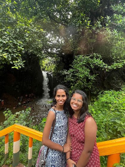 Two friends posing in front of a waterfall near Yaana.