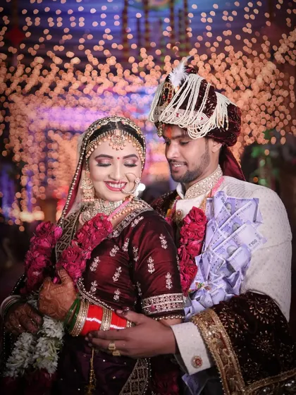 A joyful candid moment between the bride and groom, with the groom's currency garland adding a traditional touch to this happy wedding portrait.