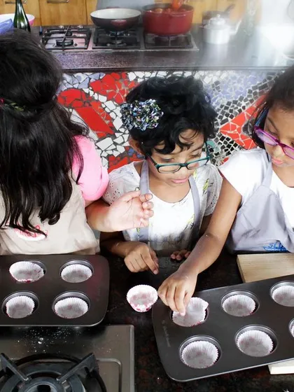 Future bakers in the making. A group of girls carefully prepares their cupcakes, learning the basics of baking in a fun and supportive setting.