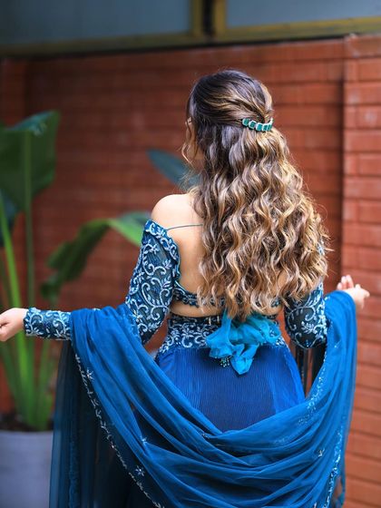 The full look with the flowing blue outfit and the beautiful curly hairstyle. It's a modern and chic combination.