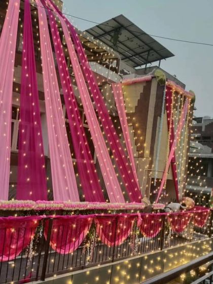 Another angle of the pink-themed house decoration, showing how the lights and drapes cover the entire facade for a complete transformation.