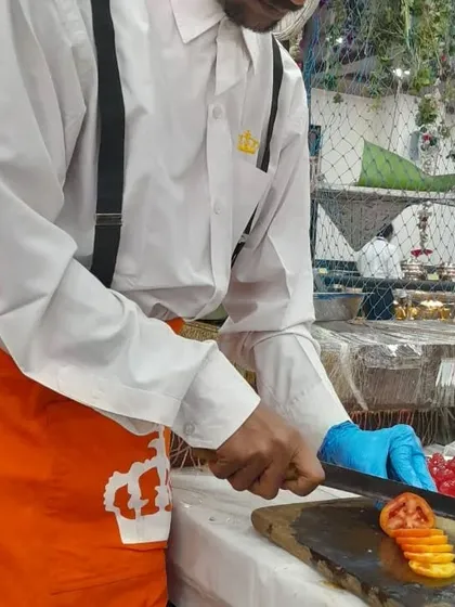 A chef from my team carefully slicing tomatoes, demonstrating the fresh preparation and attention to detail that goes into every dish.