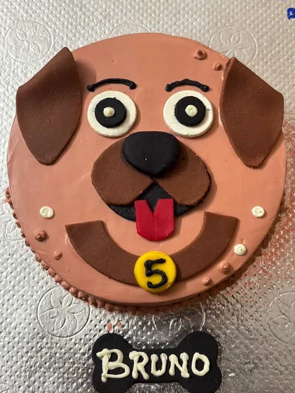 This is our Peanut Butter Buddy cake, designed for Bruno's 5th birthday. We use edible details to create a fun, cartoon-like face that every dog gets excited about.