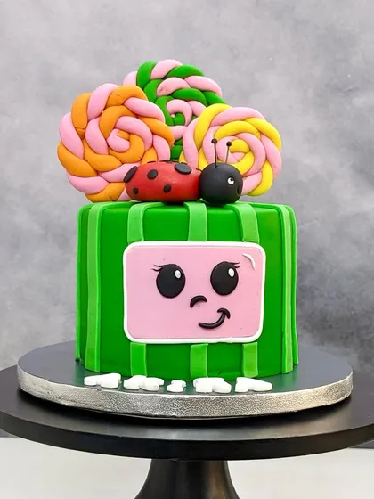 A Cocomelon-themed cake that's perfect for toddlers. The bright green design with lollipops and a ladybug is sure to make them smile.