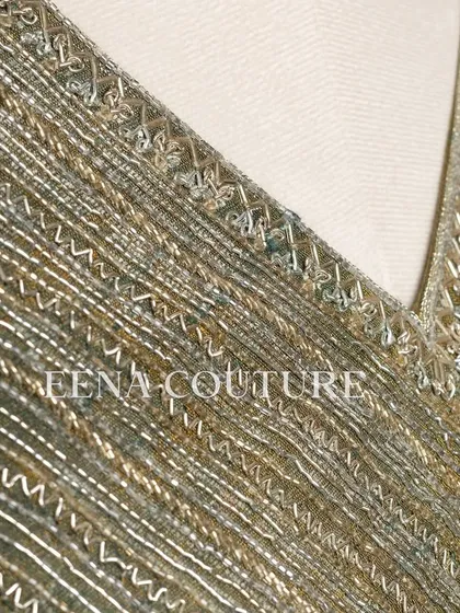 I designed this sage green raw silk blouse with geometric handwork for a timeless yet modern feel. The linear beadwork is complemented by custom floral tassels, making it a versatile piece for any occasion.