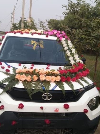 A full frontal view of the decorated Tata Punch. The design includes a bouquet on the bonnet and a garland along the roofline.