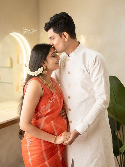A gentle kiss on the forehead is a timeless expression of love and protection. This intimate close up captures the deep bond between the parents to be.