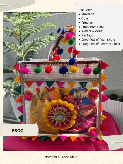 Our Jute Bag Holi Hamper is both stylish and affordable at just ₹600. It's filled with snacks like makhana and Pringles, a Paper Boat drink, gulal, water balloons, and more.