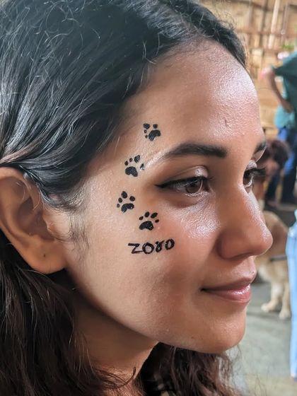 A tribute to a beloved pet named Zoro, with paw prints walking up the client's face.