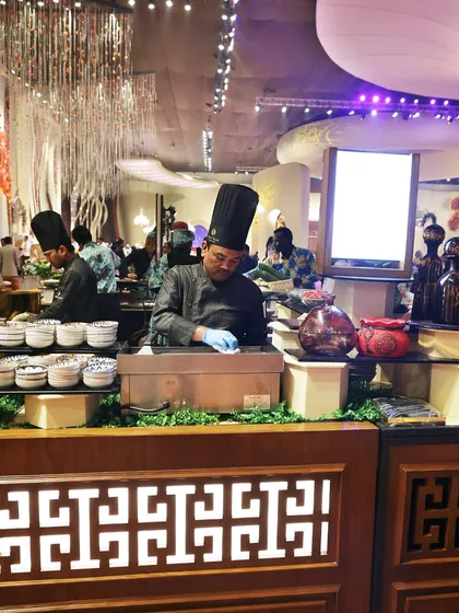 A chef at our Pan-Asian station, meticulously preparing ingredients for a live cooking demonstration.