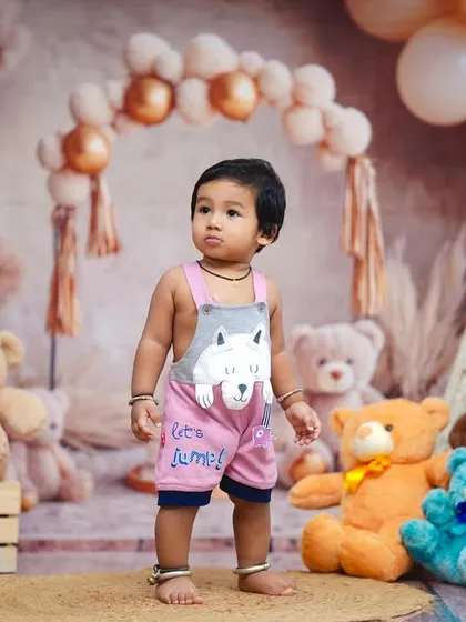 A thoughtful pose amidst a sea of cuddly friends. Our teddy bear theme is perfect for a first birthday.