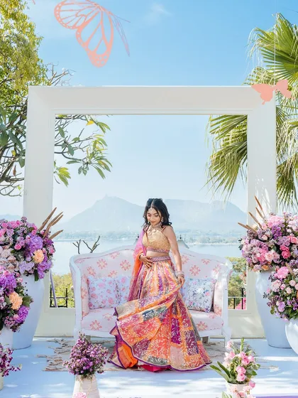 A stunning portrait of the bride in her multi-colored lehenga, framed by the lakeside view in Udaipur.