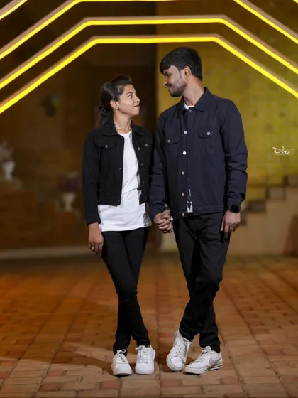 A stylish night shot of a couple holding hands. The geometric light patterns in the background add a modern and cool vibe.