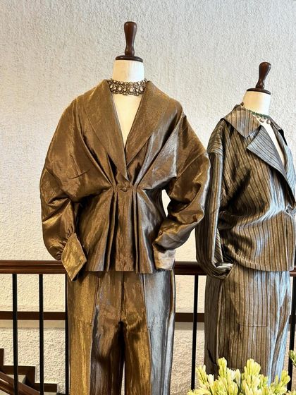 A closer look at two co-ord sets in shimmering bronze and silver, featuring unique draped tops and matching trousers.