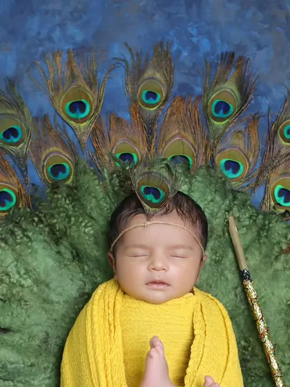 Our little Krishna theme, featuring a newborn wrapped in yellow and adorned with a peacock feather. This is a beautiful way to celebrate faith and tradition.