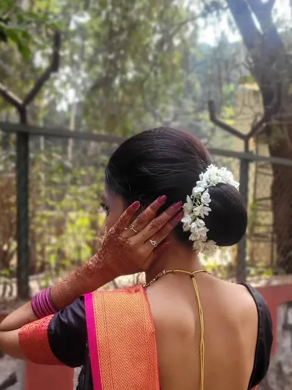No traditional look is complete without the right hairstyle. Here is a classic low bun, beautifully adorned with a fresh *gajra* (jasmine garland) that adds elegance and a lovely fragrance.