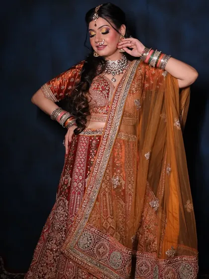 This stunning rust-orange bridal lehenga is captured from different angles, showing off its rich color and intricate embroidery. It's a beautiful alternative to traditional red for the modern bride.