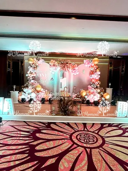 The main stage for the twins' "one-derful" boho birthday. The setup features marquee letters spelling their names, a large "1," and two beautiful balloon arrangements against a soft pink backdrop.