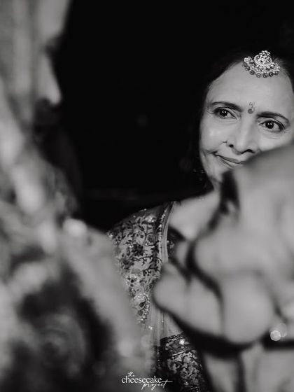 A close-up, emotional black and white shot of a mother's face during the Vidaai.