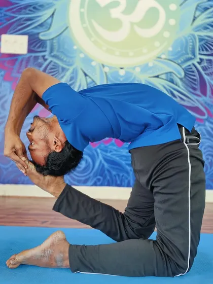 A practitioner demonstrates Kapotasana (Pigeon Pose), an advanced backbend that requires open shoulders, hip flexors, and a flexible spine.