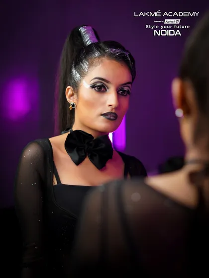 A mirror portrait of a gothic-inspired glam look. The black bow tie and sharp makeup lines create a powerful and confident image.