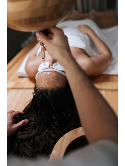 This is another view of a Shirodhara treatment, a cornerstone of my approach to hair fall. The continuous flow of warm oil on the forehead pacifies the doshas responsible for hair loss. This, combined with internal detoxification, provides a holistic and long-term solution.