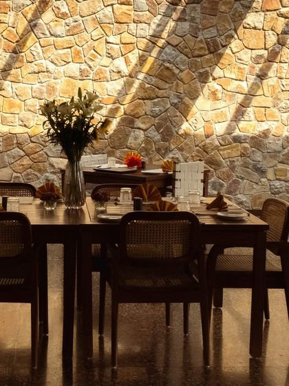 The dining room, where a stone wall and natural light create a beautiful setting for enjoying our European-inspired cuisine.