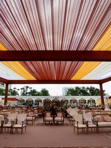 A wide view of the Bhaat ceremony setup, with a colorful draped ceiling and elegant seating arrangements.