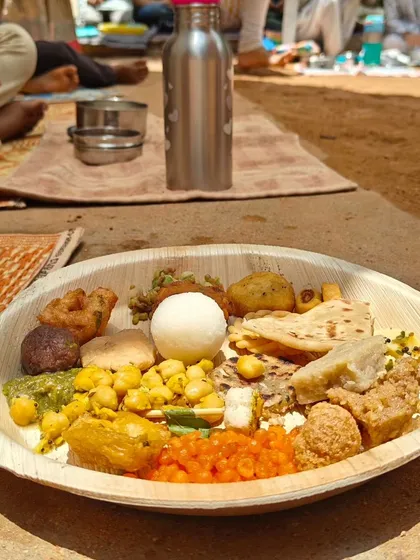 A plate filled with a variety of foods from different regions of India, part of our Independence Day potluck. Sharing food is a powerful way to celebrate our country's rich and pluralistic heritage.