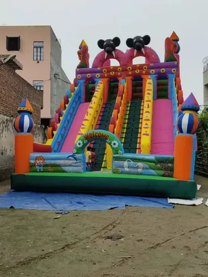 This big sliding bouncy features multiple lanes and a vibrant pink and orange color scheme, designed to attract attention.