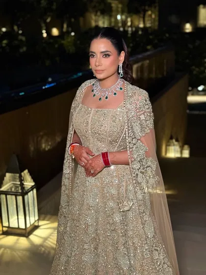 The bride's reception look captured in the warm evening light. Her makeup is radiant and polished, with a soft smoky eye that enhances her features beautifully.