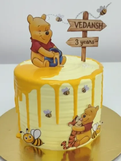 A sweet Winnie the Pooh cake with a honey drip effect. This vanilla cream cake is 100% homemade and chemical-free, making it a healthy and fresh treat for a 3rd birthday.