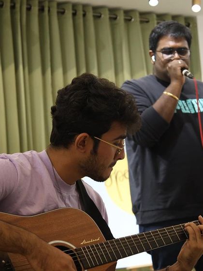 A musical duo collaborates on stage for a unique performance.