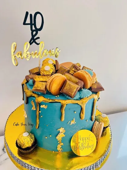 Turning 40 is a milestone that deserves a showstopper. I designed this '40 & Fabulous' cake with a rich teal buttercream, a dramatic gold drip, and topped it with Ferrero Rocher, macarons, and chocolate bars for pure indulgence.