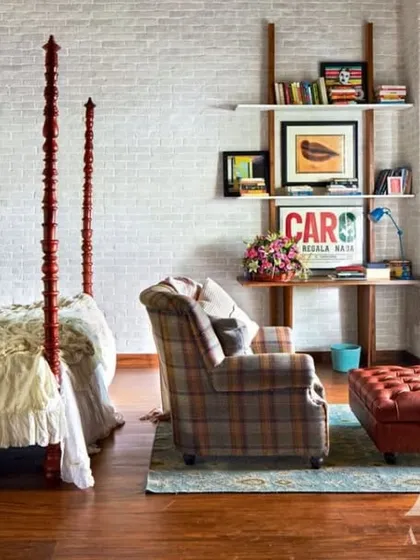 In Kangana Ranaut's bedroom, a white brick wall provides a rustic, textured backdrop for a classic four-poster bed. The design blends her Himachali roots with a modern aesthetic, creating a space that feels both grounded and light.