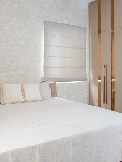 Here, you can see the sleek, high-gloss wardrobe with mirrored strips. This not only provides ample storage but also makes the room feel larger and brighter.