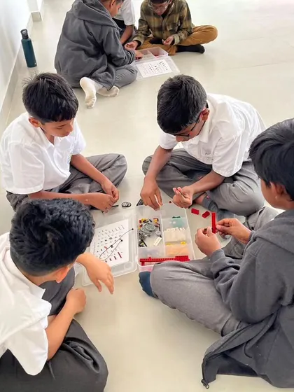 A team of boys from Sadhu Vaswani International School works together to assemble their LEGO model, learning valuable teamwork and problem-solving skills.