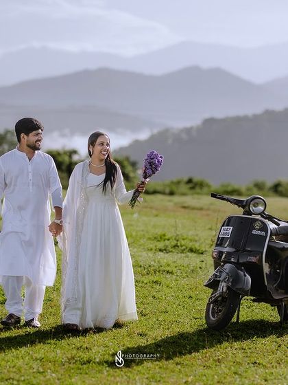 A lovely walking shot, hand-in-hand, with the scooter and mountains creating a perfect scene for a save-the-date card.